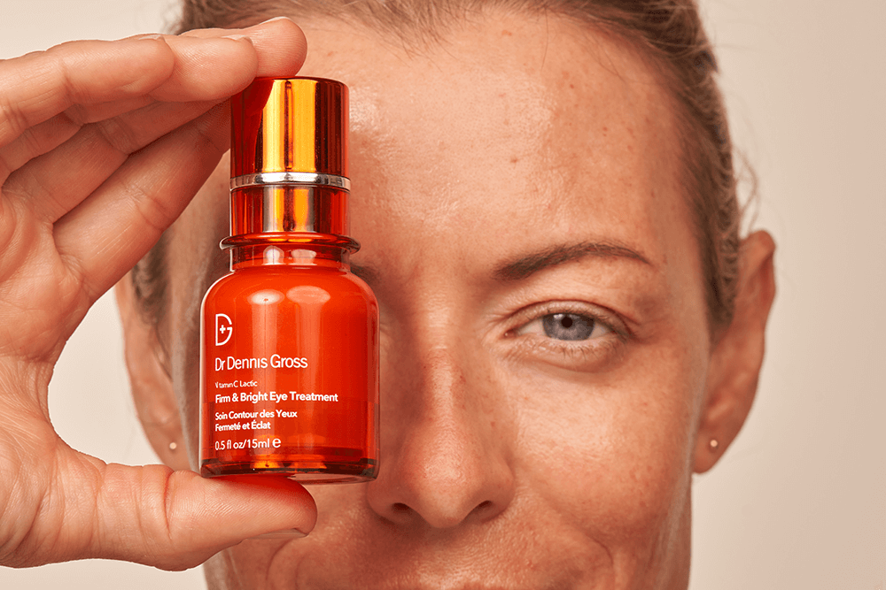 Woman showing Dr. Dennis Gross Vitamin C Lactic Firm & Bright Eye Treatment